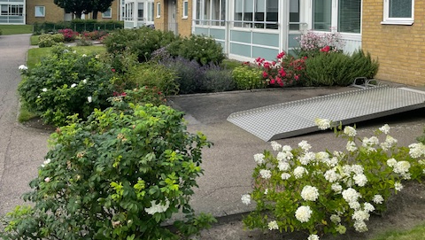 Bild på föreningens hus med rabatter och blommor